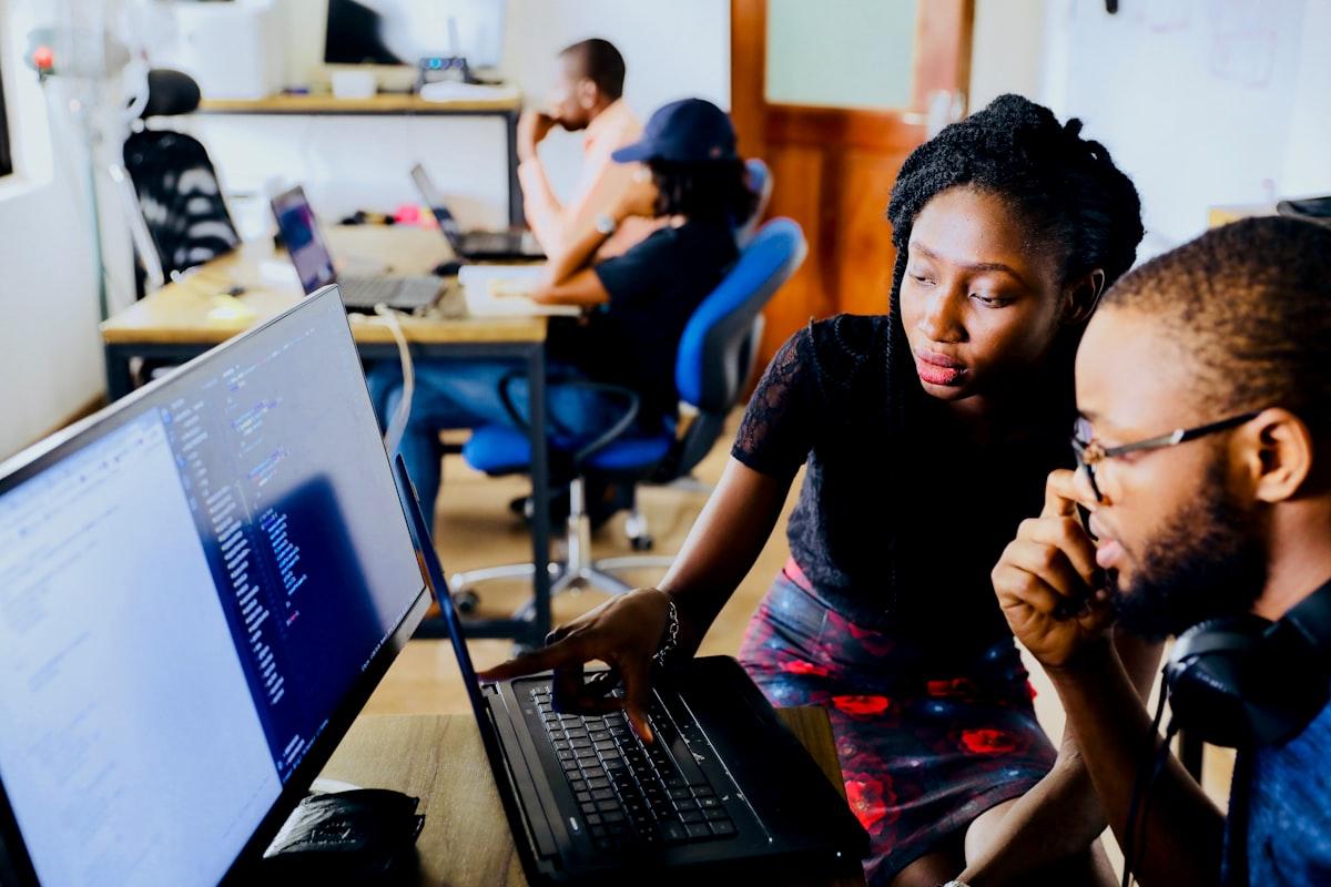 African professional smiling while working on a laptop